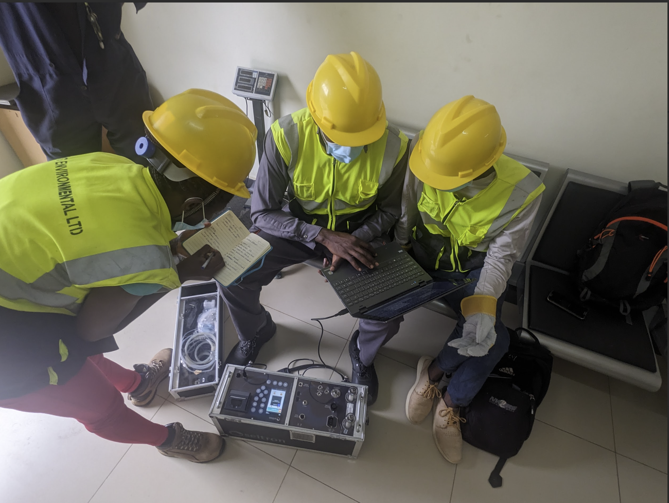 Technical team reviewing emissions monitoring equipment